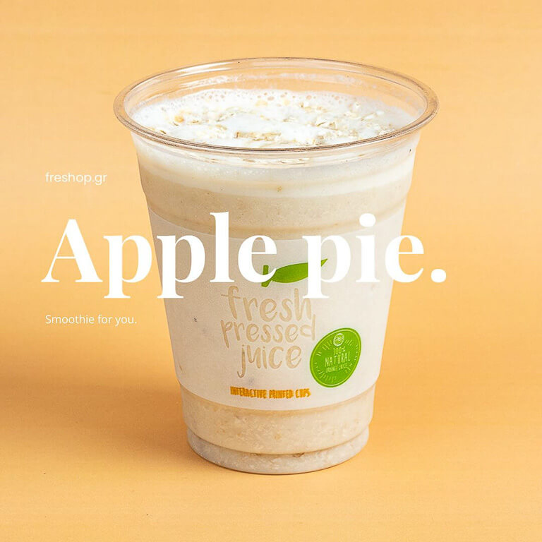 transparent glass with apple pie smoothie on a yellow background.