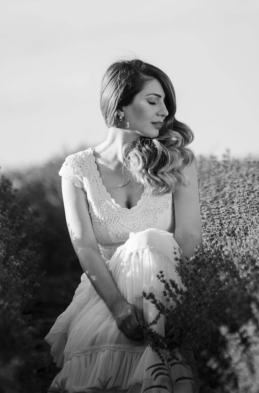 white and black photo of a woman standing and looking at the side in an outdoor space