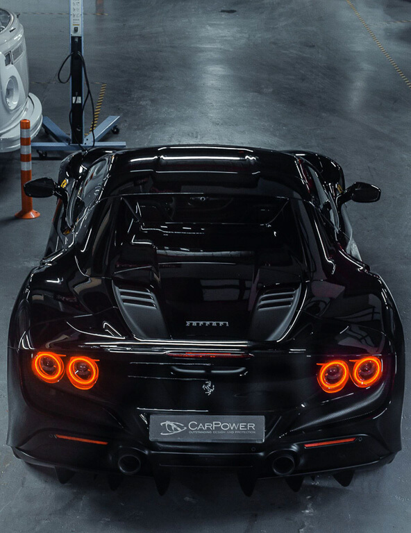 black sports Ferrari photographed from above the rear