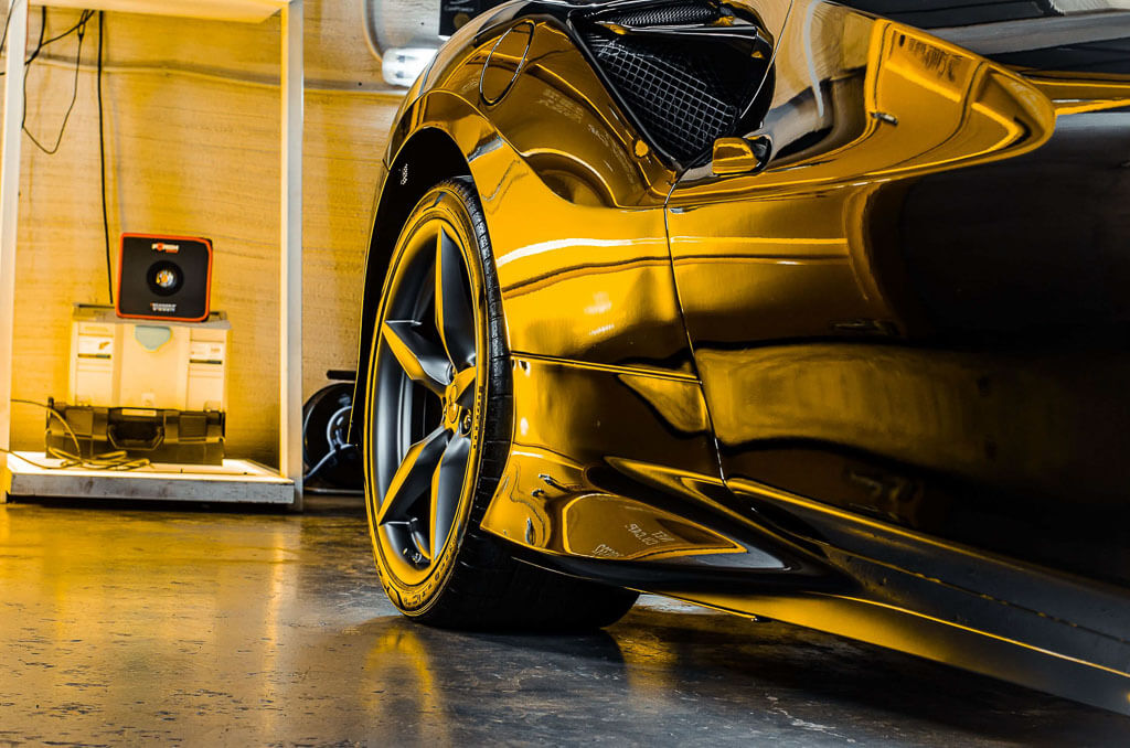 a black sports Ferrari photographed from a low-angle view of its rear end