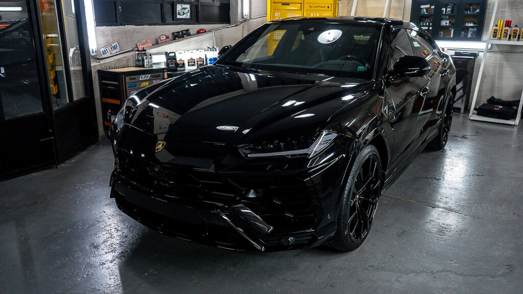 A black Lamborghini Jeep from the front high diagonal in the garage