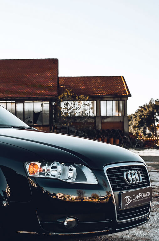 the front end of an Audi black car was photographed on the side in front of an old building