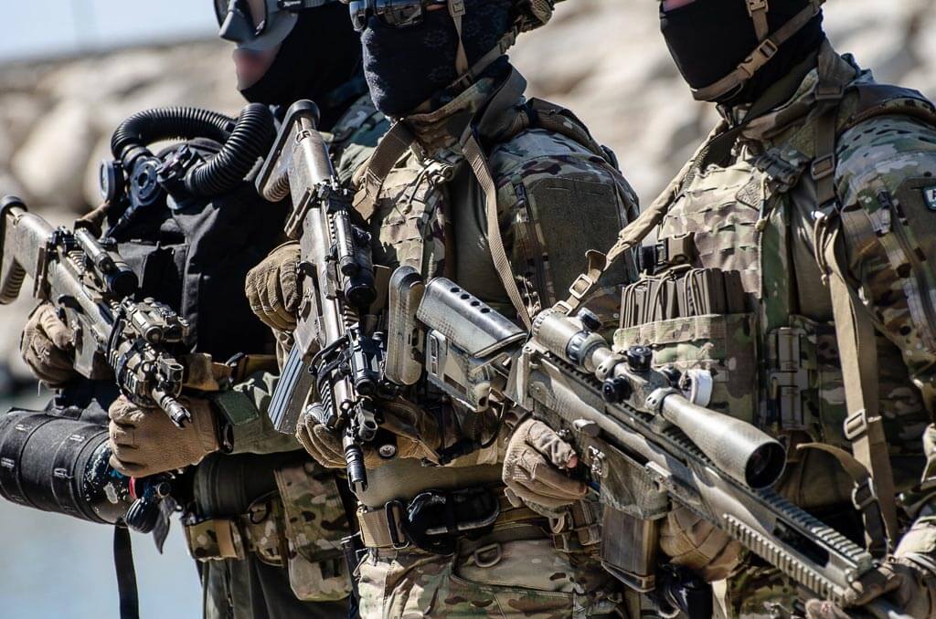 Three soldiers in uniform were holding automatic weapons. They're wearing helmets