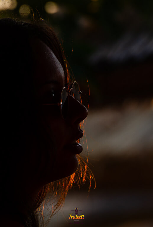 dark photo of a girl wearing black sunglasses and looking at the side