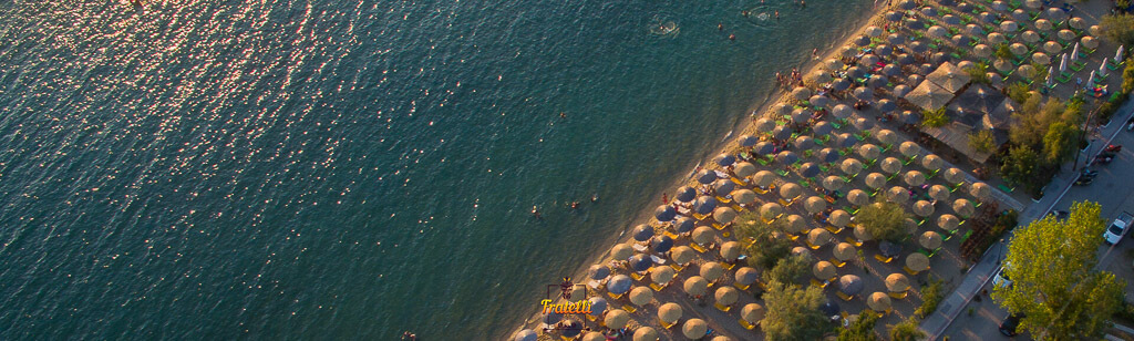 side panoramic drone photo showing the sea, the beach bar Fratelli, and the turquoise sea