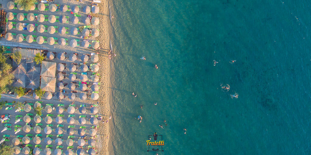 drone photo from above showing the sea, the beach bar Fratelli, people swimming, and the sea