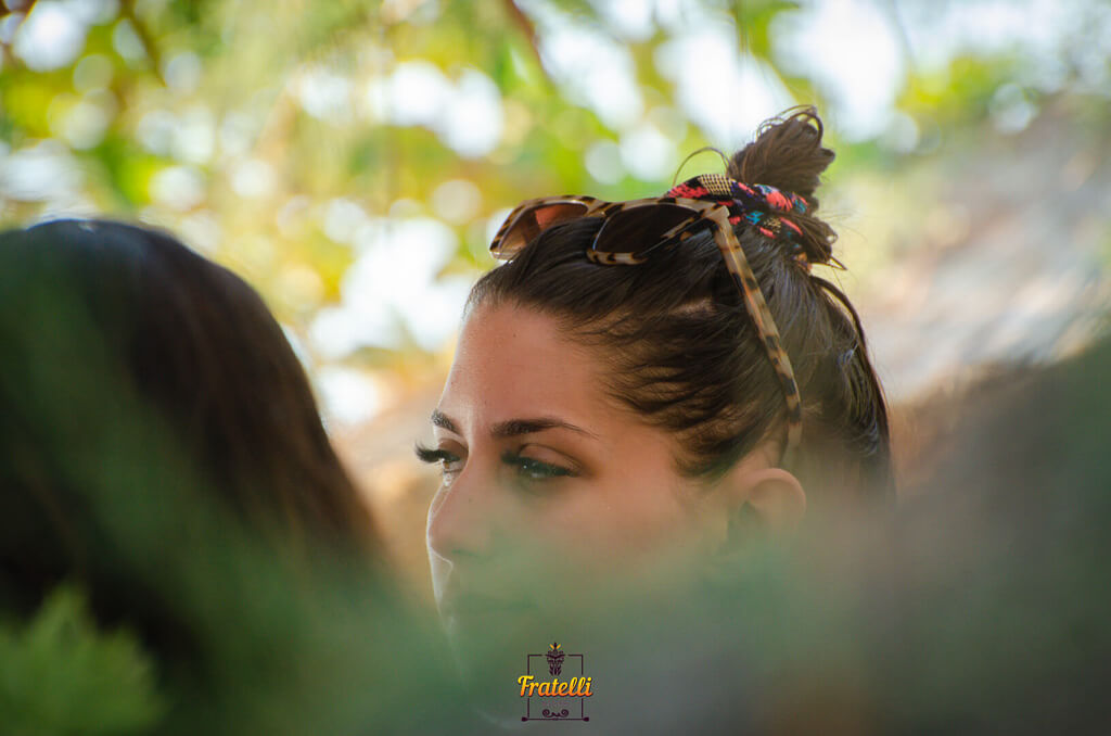 woman's face looking to the side, her dark hair caught in a multicolored hairpiece