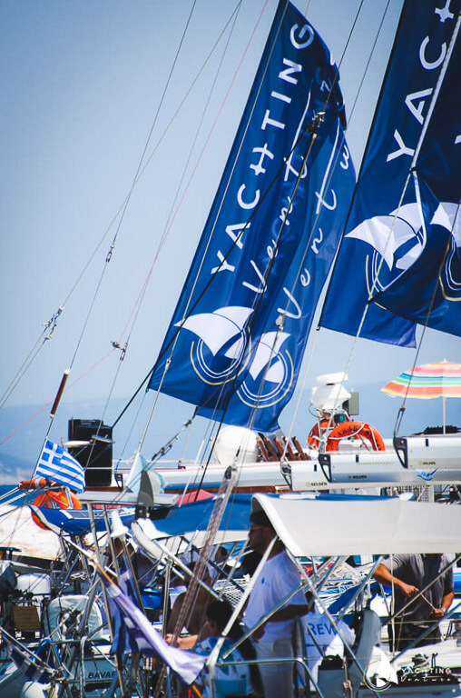 sailing boats with people and flags in blue with the word ''yachting''.