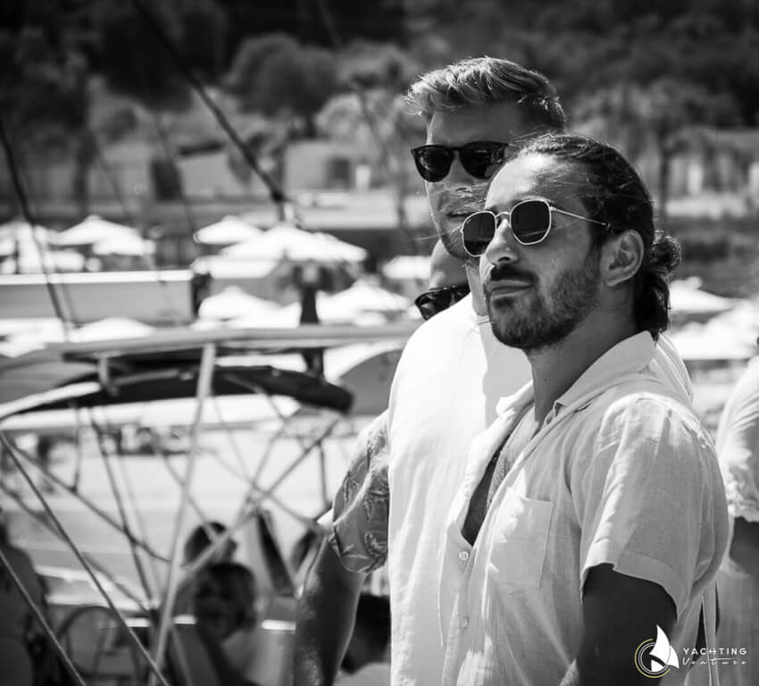 white and black photo with two men with sunglasses looking to the side while on a boat